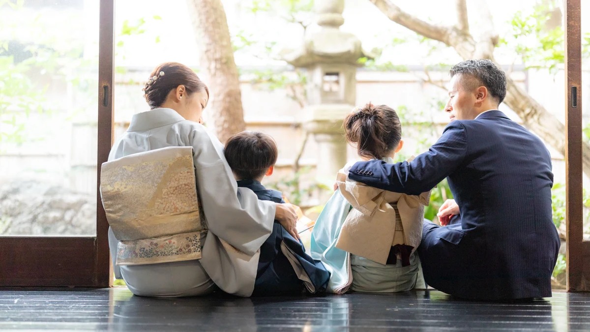 京町家の縁側で七五三の着物姿の子どもたちと祖父母が並ぶ様子