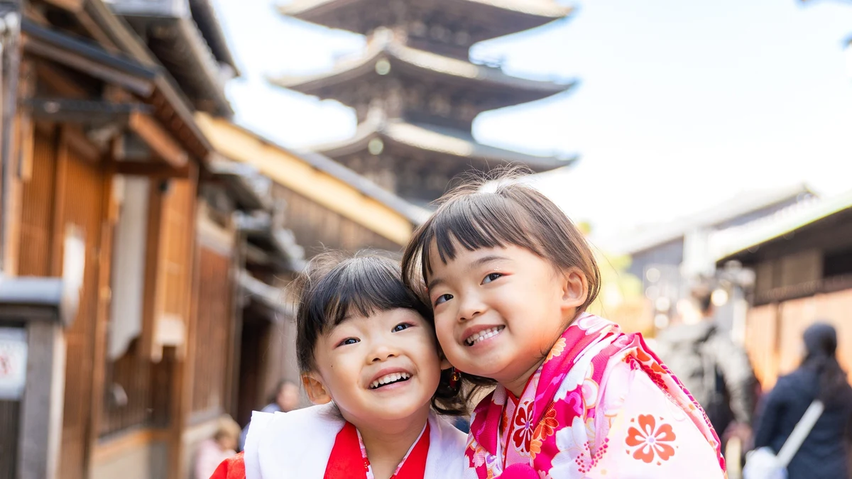 京都の祇園で七五三の着物姿の姉妹が並んで微笑む写真